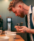 A handsome man trying coffee during a "coffee cupping" or coffee tasting. 