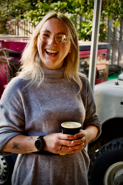 Smiling woman looking happy with the coffee she has made