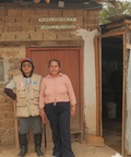 Two farm workers standing in front of one of their storehouses.