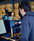 Person standing in front of a small coffee roaster